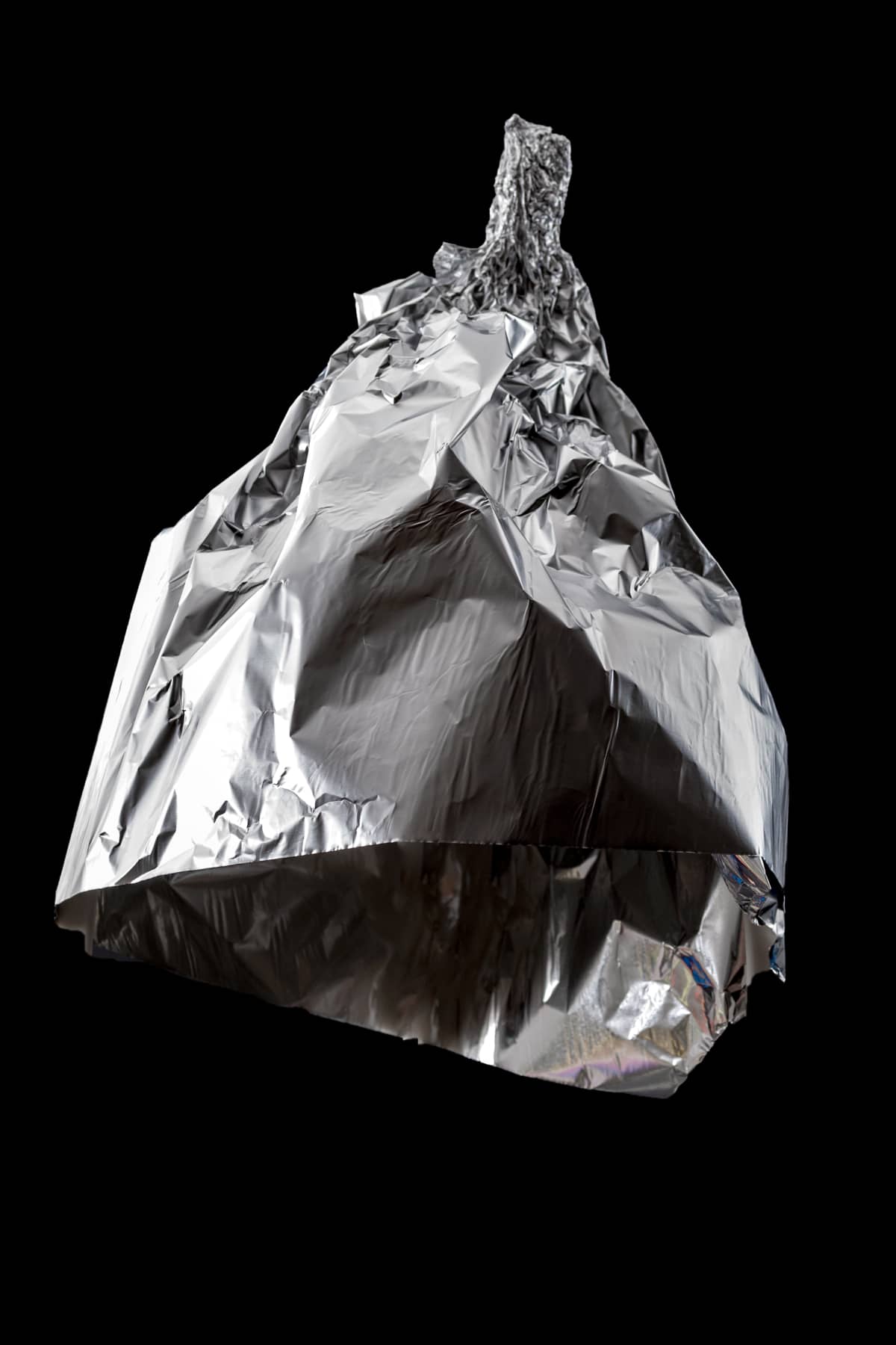 Aluminum foil crumbled into a triangle shape against a black background