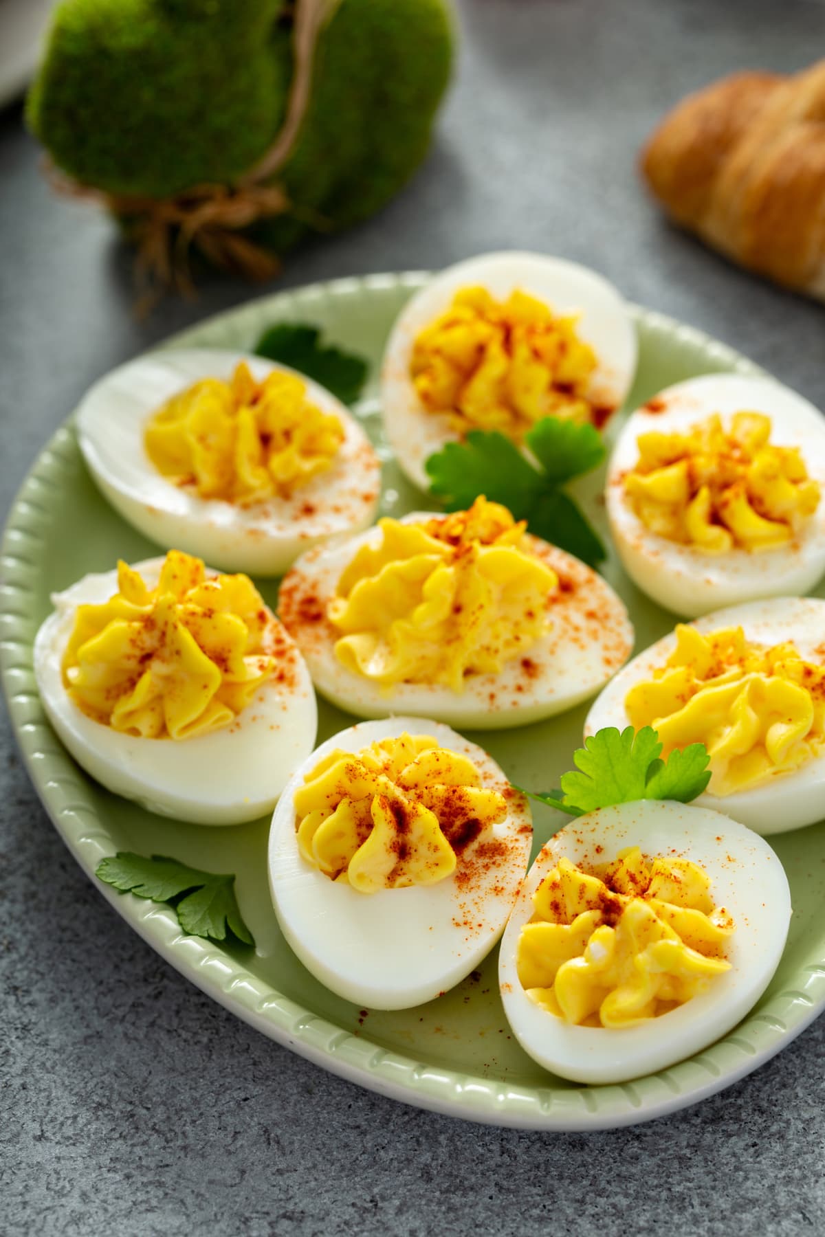 Deviled eggs with smoked paprika on a green plate