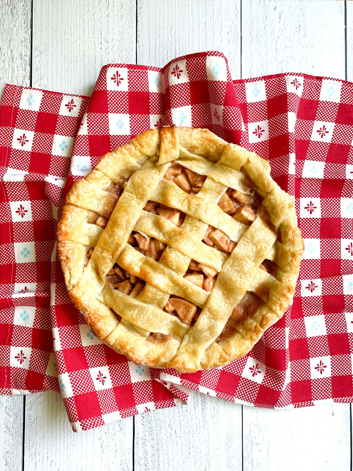 Apple pie with lattice crust on checkered tablecloth