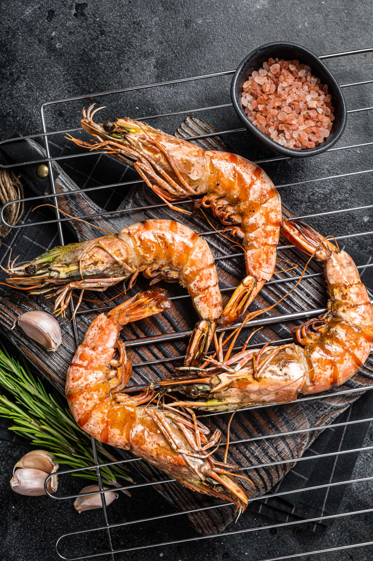 Round of red giant shrimps with lemon and ice. Blue painted scratched background. Seafood top view. Copy space. Prawns with lemon ready to eat. Argentine prawns traditional food.
