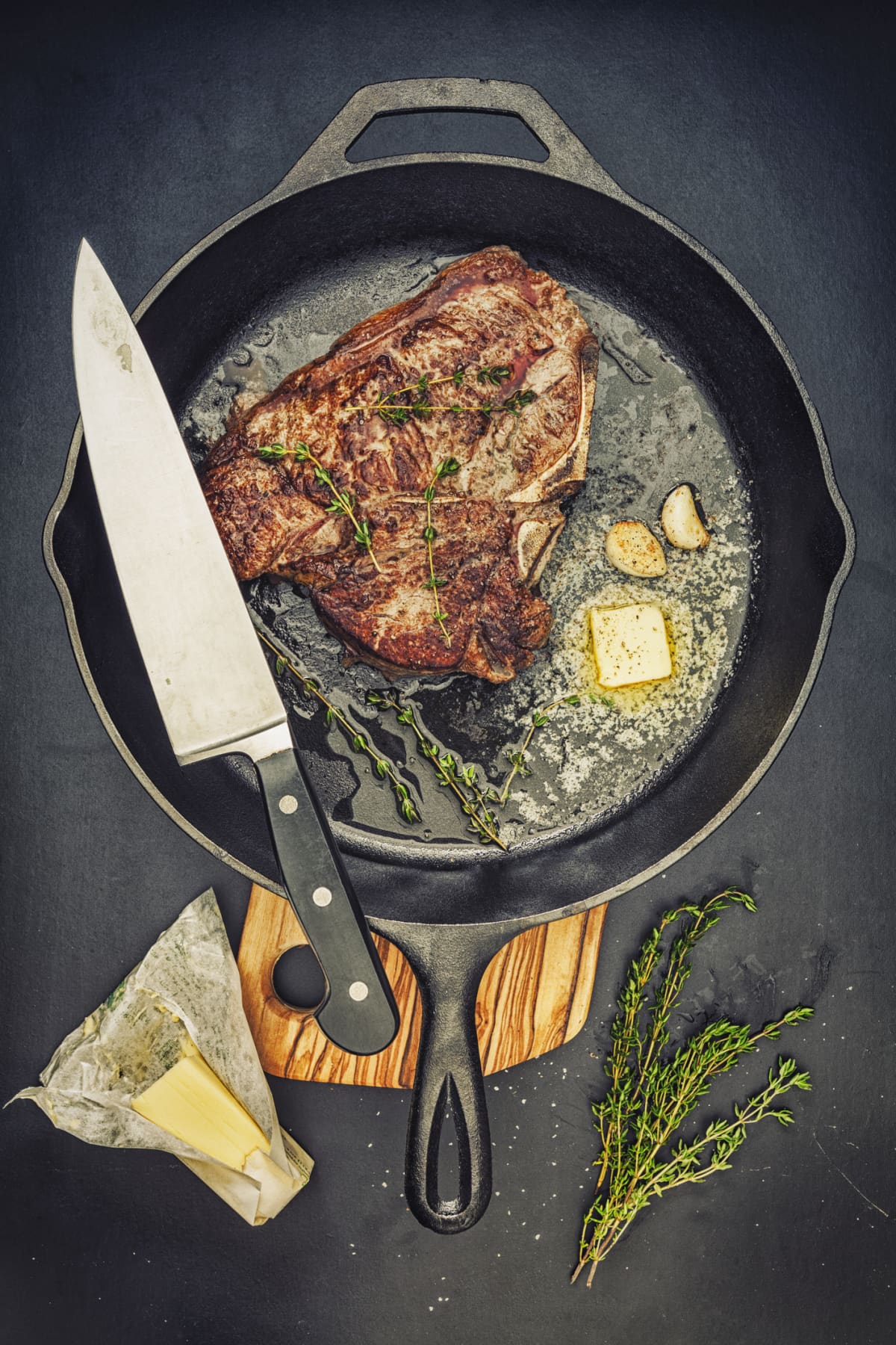 T-Bone steak in a cast iron pan, with thyme garlic and butter