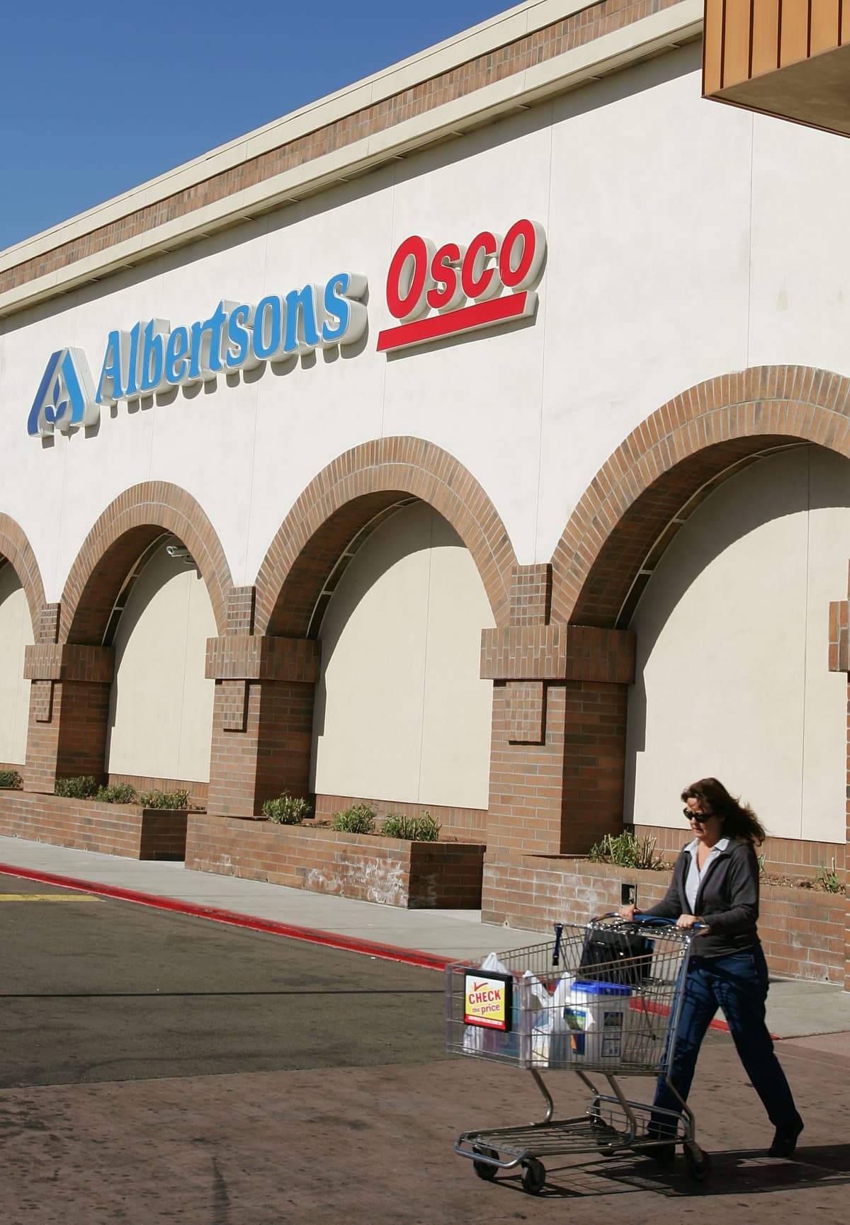 TEMPE, AZ - JANUARY 23:  A customer leaves an Albertsons store January 23, 2006 in Tempe, Arizona. An investment group that includes grocery store operator Supervalu Inc. and the drugstore chain CVS Corp. announced Monday it would would buy Albertsons for $17.4 billion in cash, stock and debt.  (Photo by Ethan Miller/Getty Images)