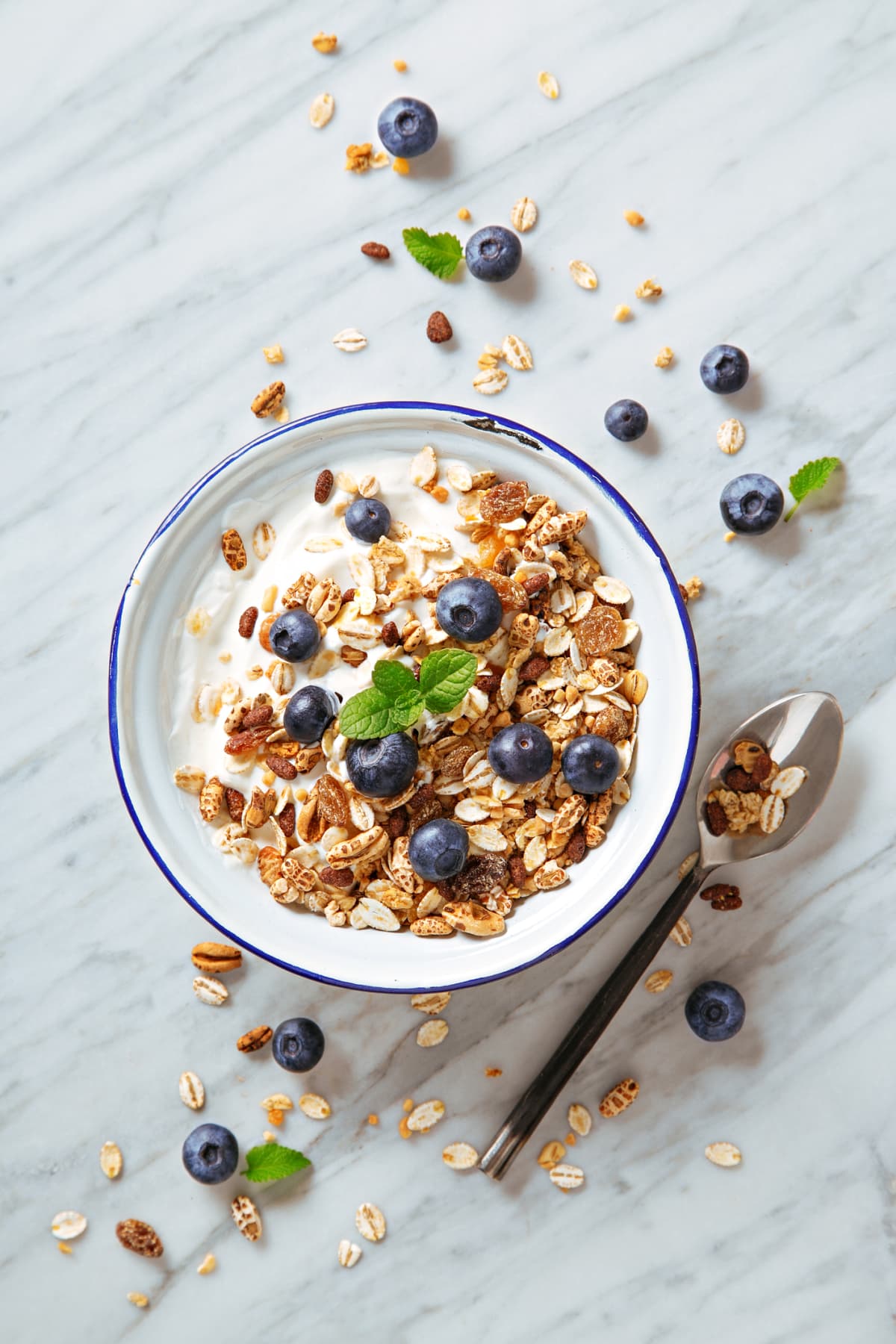Cereals breakfast with blueberries on a marble background. Healthy morning meal with fresh berries. Top view