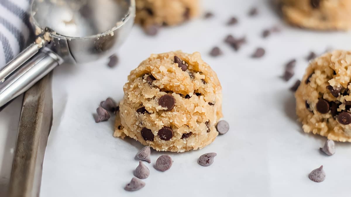 A scoop of chocolate chip cookie dough on parchment paper