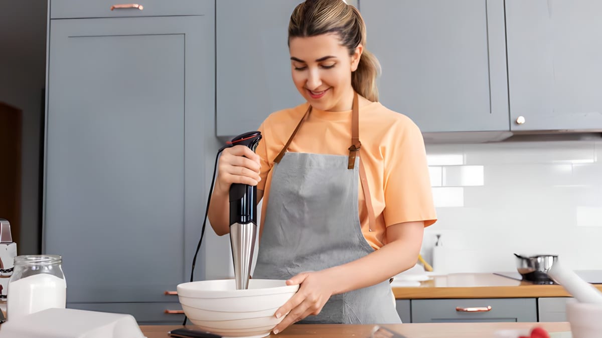 Woman in the kitchen using an immersion blender