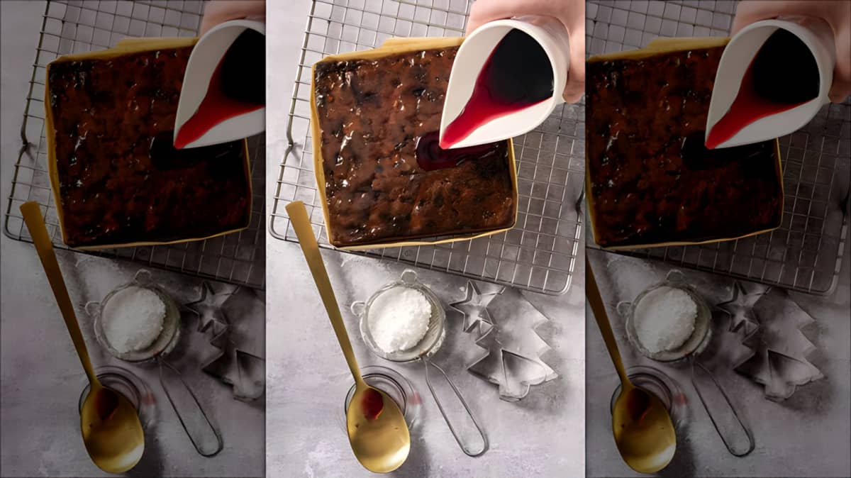 Hand pouring syrup over a Caribbean black cake