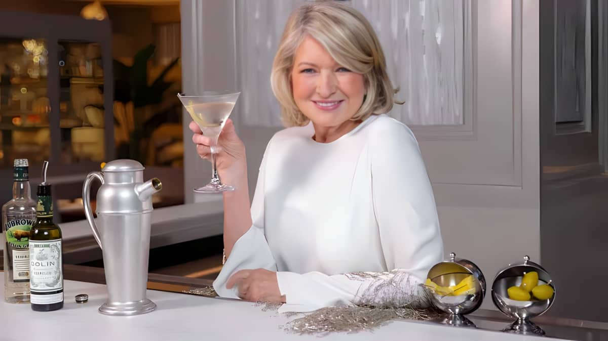 Martha Stewart smiling and holding a martini glass