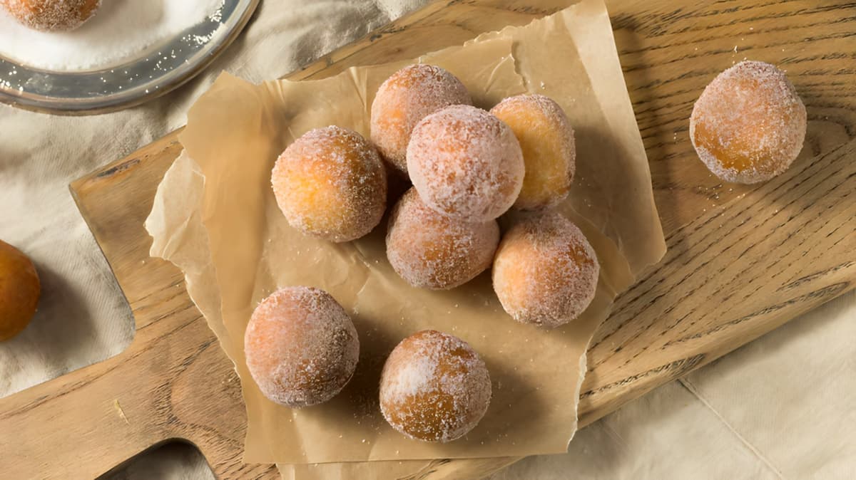 Powdered donut holes on brown parchment paper
