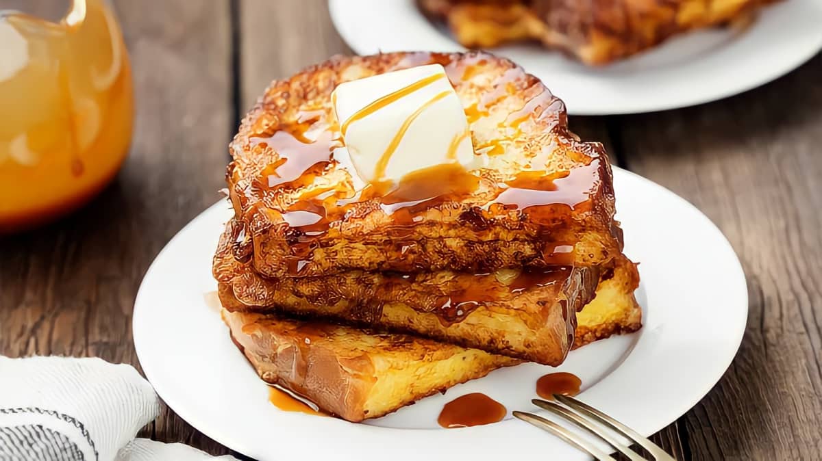 Stack of french toast topped with butter and syrup