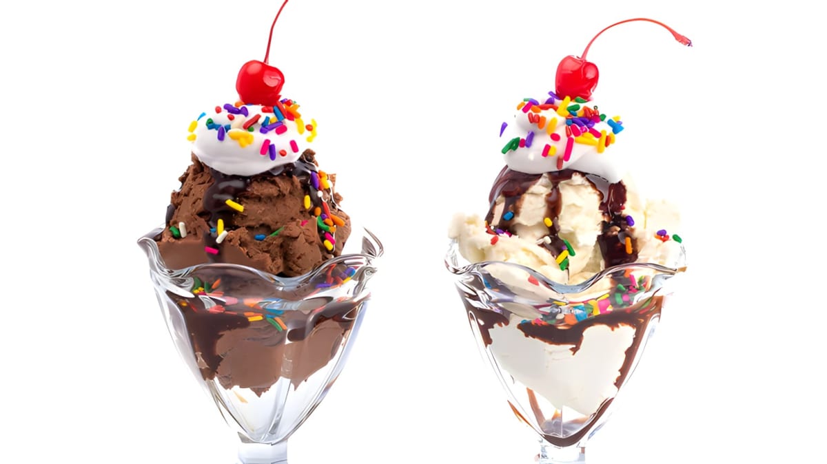 An ice cream sundae with sprinkles, chocolate syrup, whipped cream, and a cherry