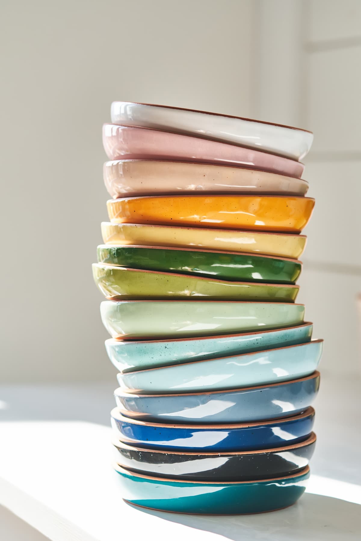 Ceramic dinner plates stacked in a tall pile