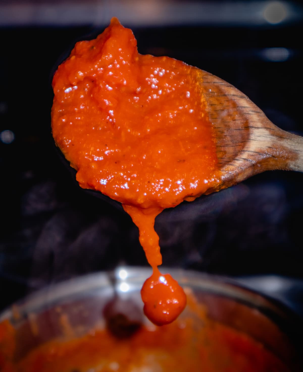Cooked pasta sauce on wooden spoon