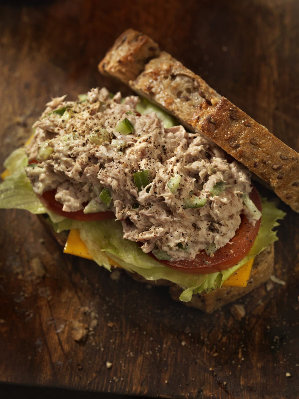 "Close up of a tuna salad sandwich made with mayonnaise, leaf lettuce and whole wheat bread, isolated on white. More tuna sandwich..."