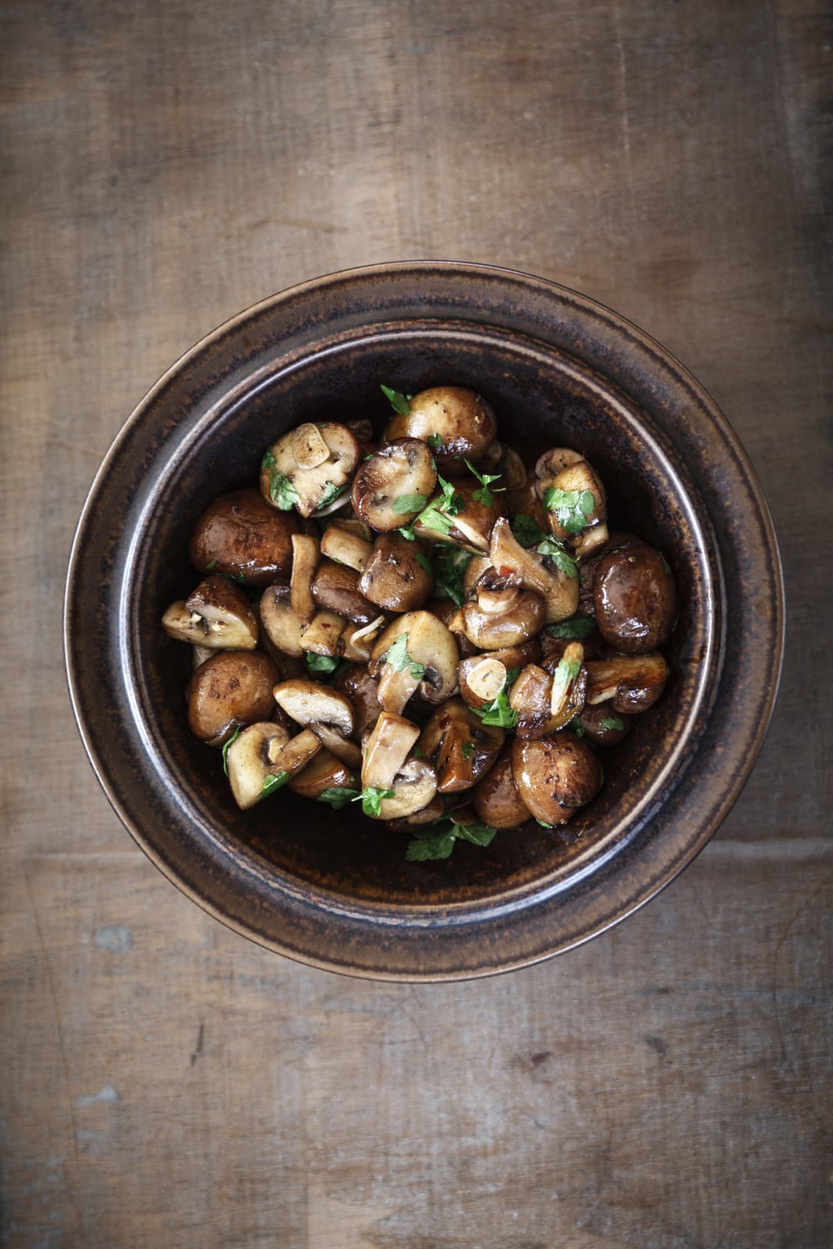 Bowl of mushrooms with fresh herb garnishes