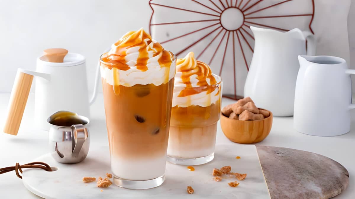 An iced latte with whipped cream and caramel drizzle