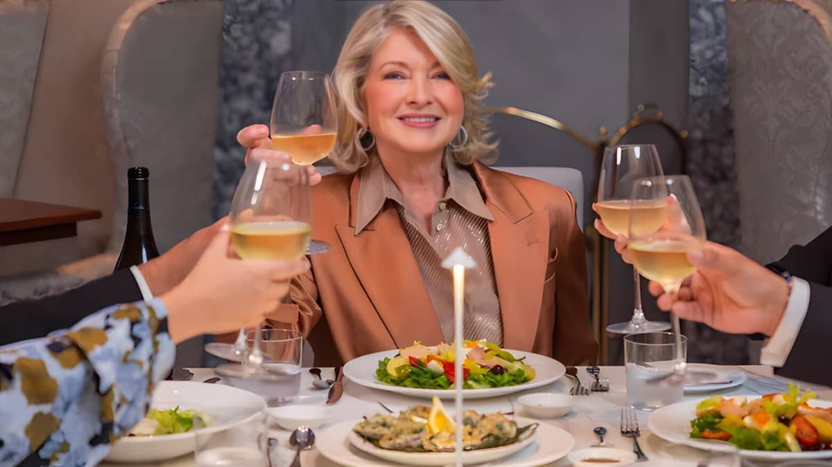Martha Stewart smiling and holding up a glass of wine