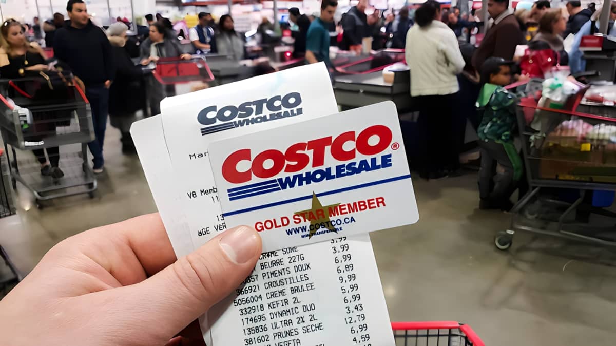 Fingers holding a Costco receipt and membership card