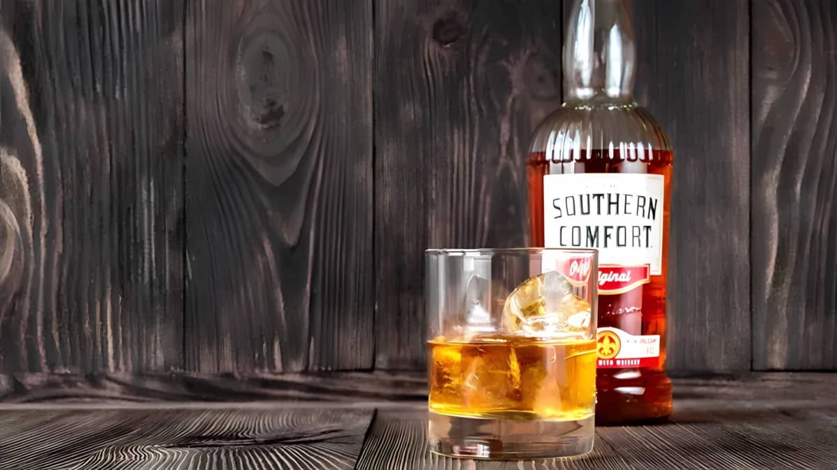 A bottle of Southern Comfort behind a glass
