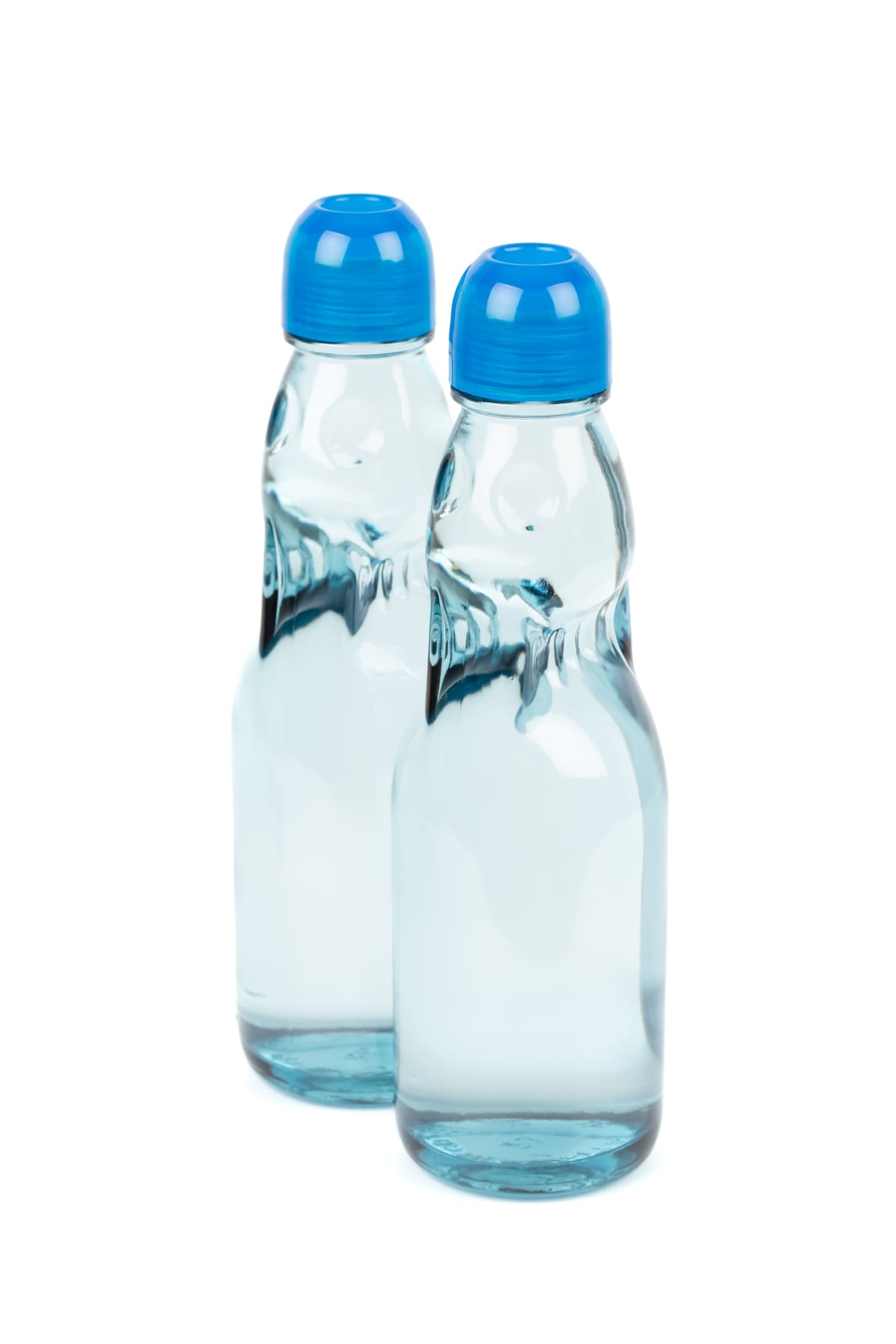 Two bottles of ramune soda against a white background