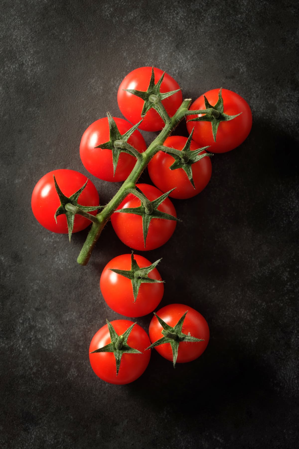 A bunch of tomatoes on a vine