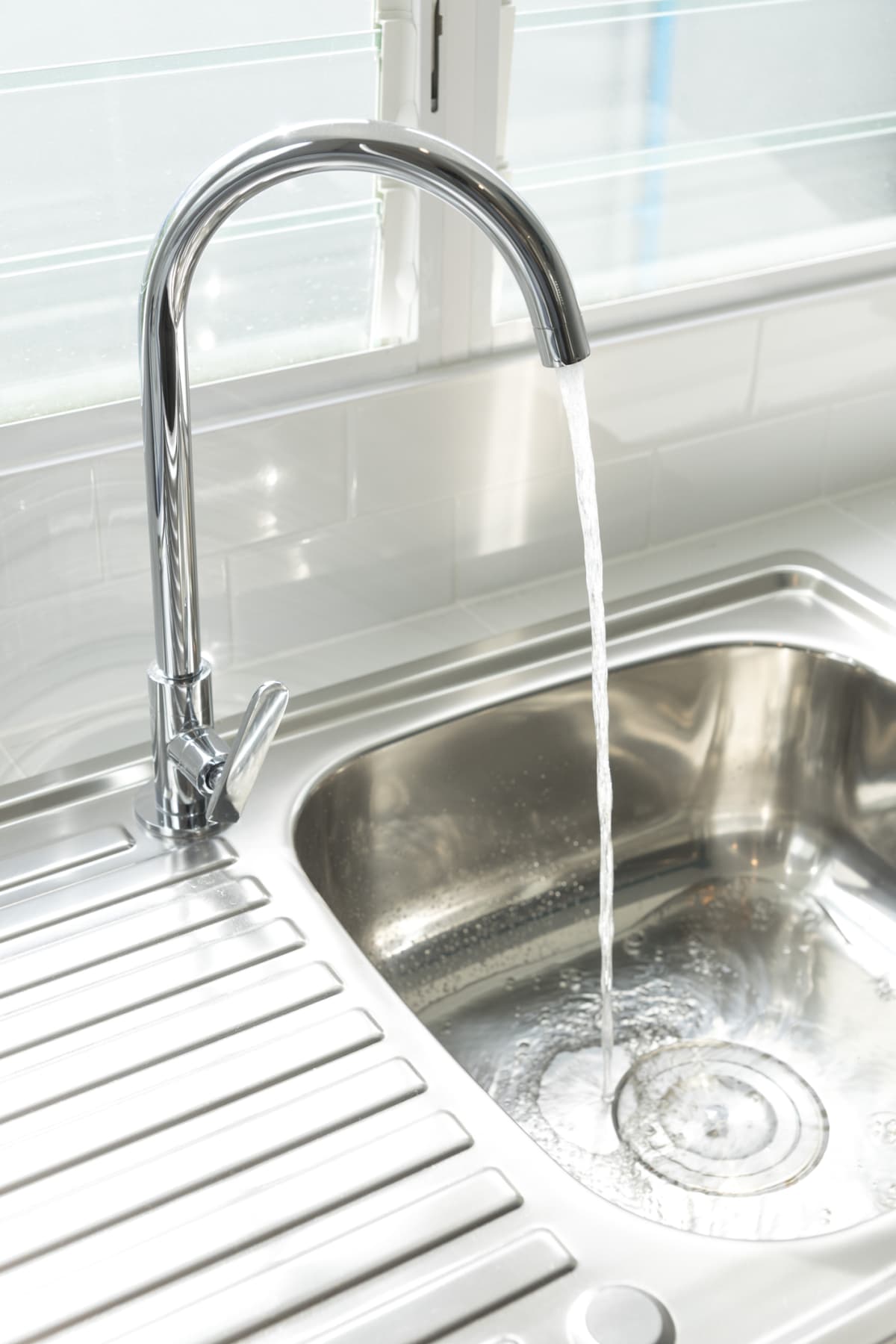 Stainless steel sink with water running from the faucet