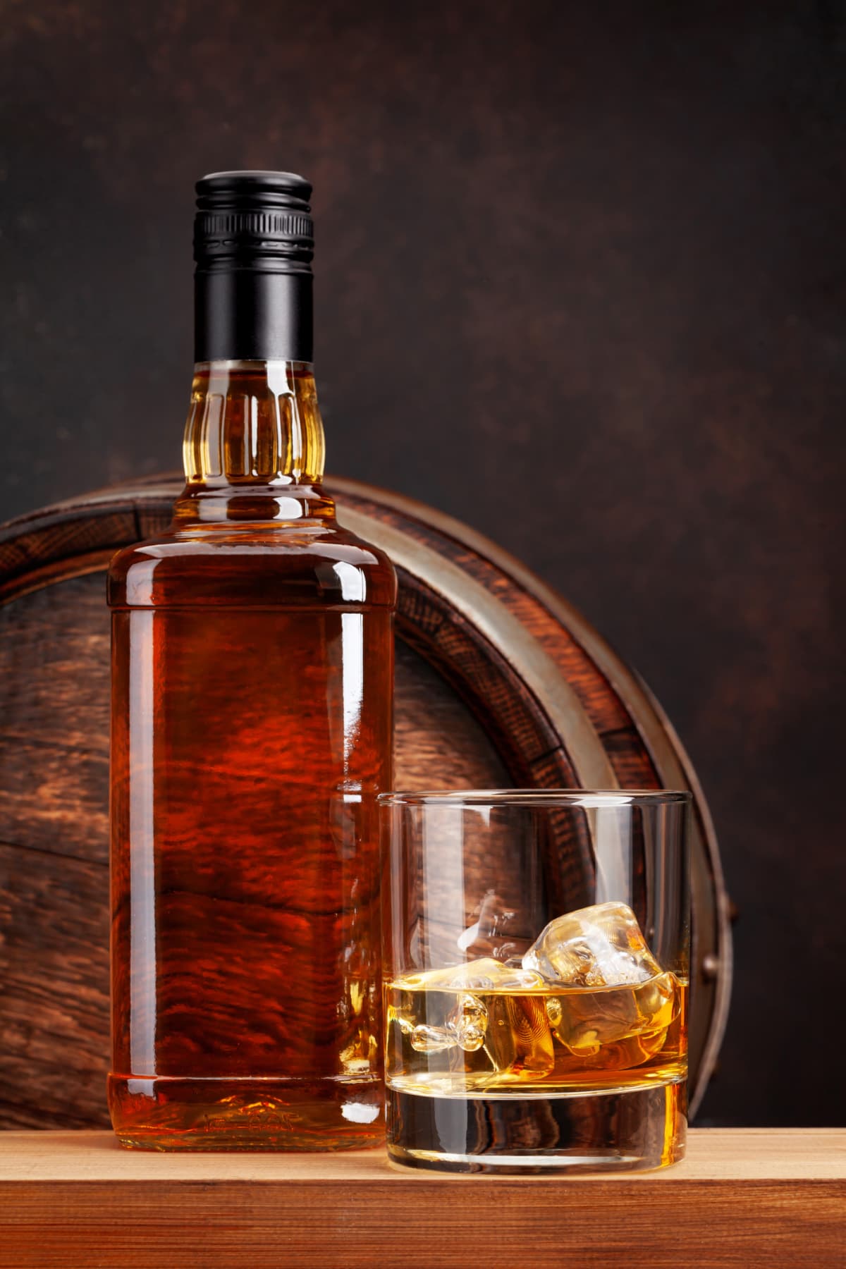 Scotch whiskey bottle, glass and old wooden barrel. With copy space