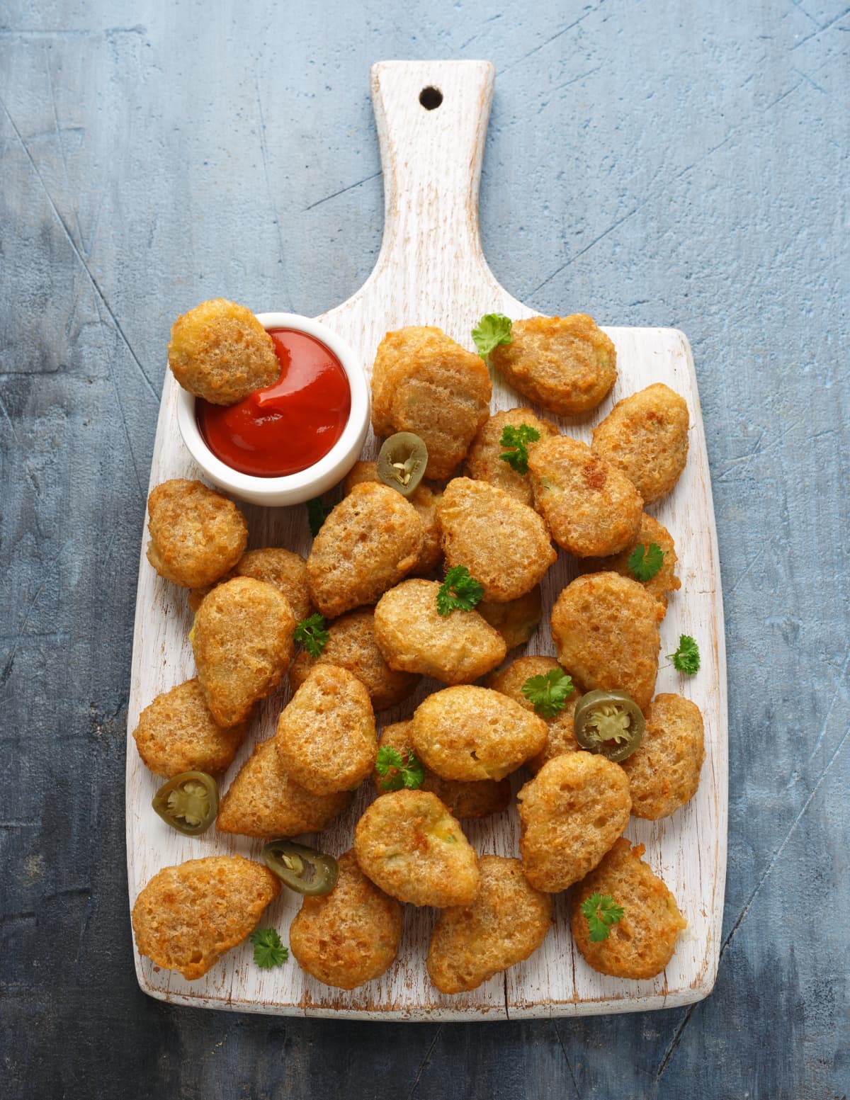Crispy Jalapeno Popper with creamy cheese battered on white wooden board.