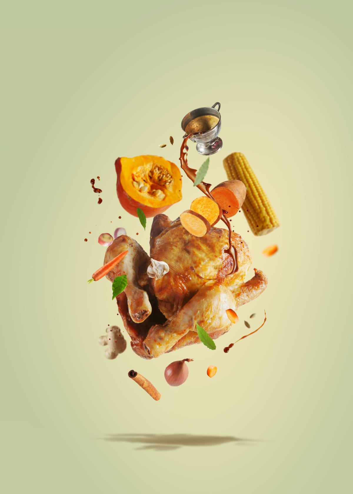 Creative Thanksgiving food with pouring sauce on flying roasted whole turkey, pumpkin, sweet potato, corn and carrots flying in the air. Levitation food concept with traditional festive american dinner. Front view.