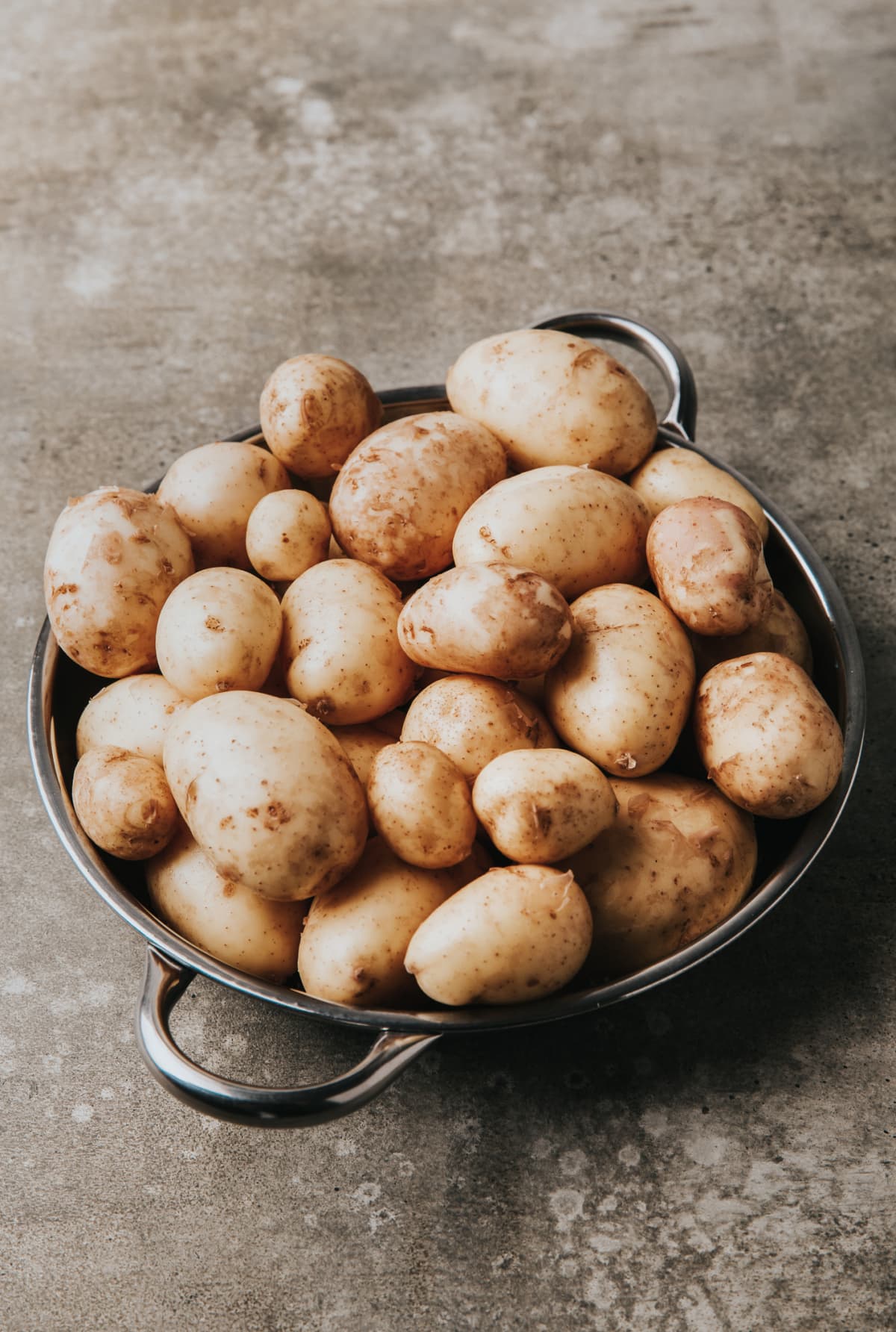 Raw potatoes in tray on a table