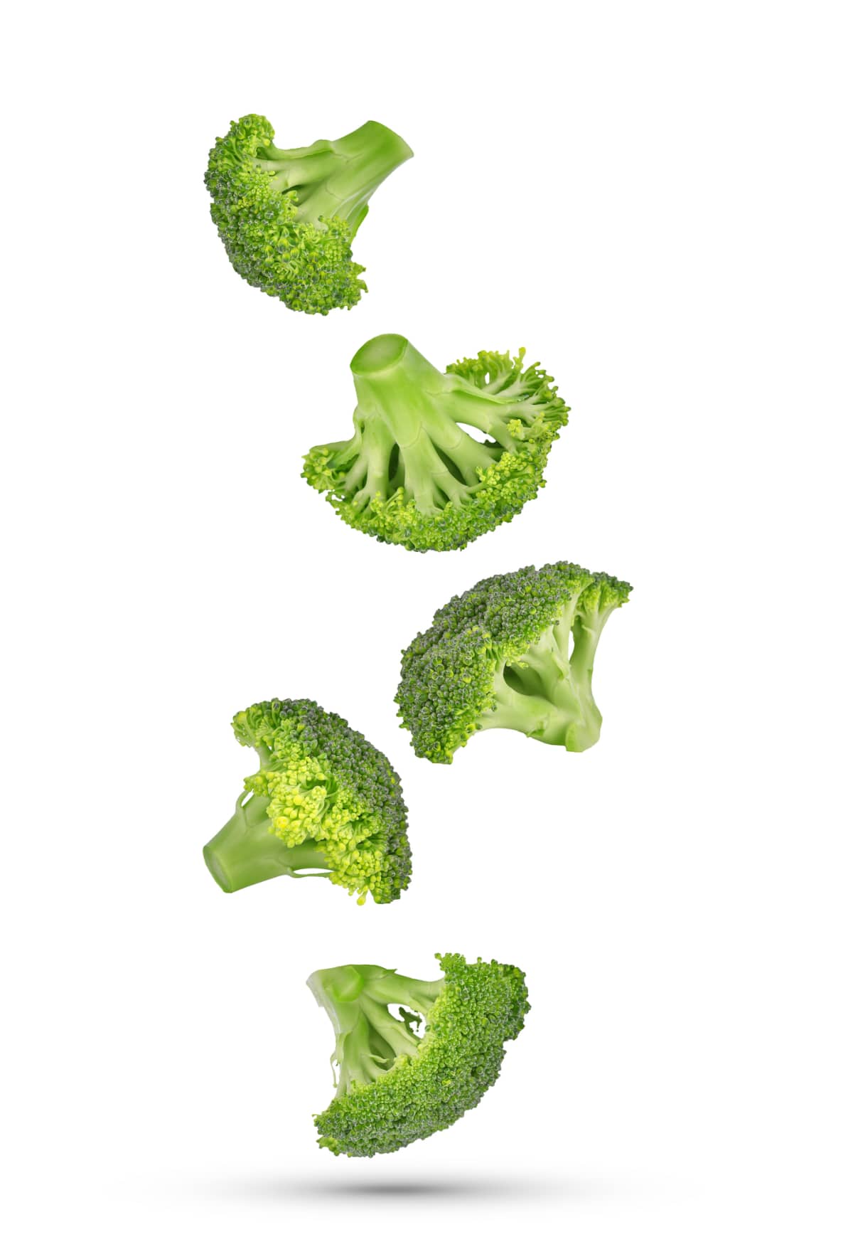 Pieces of broccoli falling in the air isolated on white background