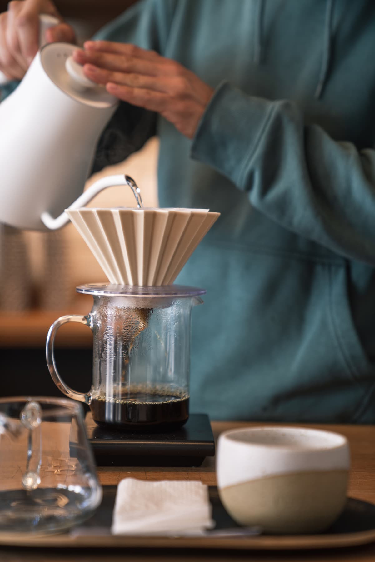 Barista making pour-over coffee in coffee shop