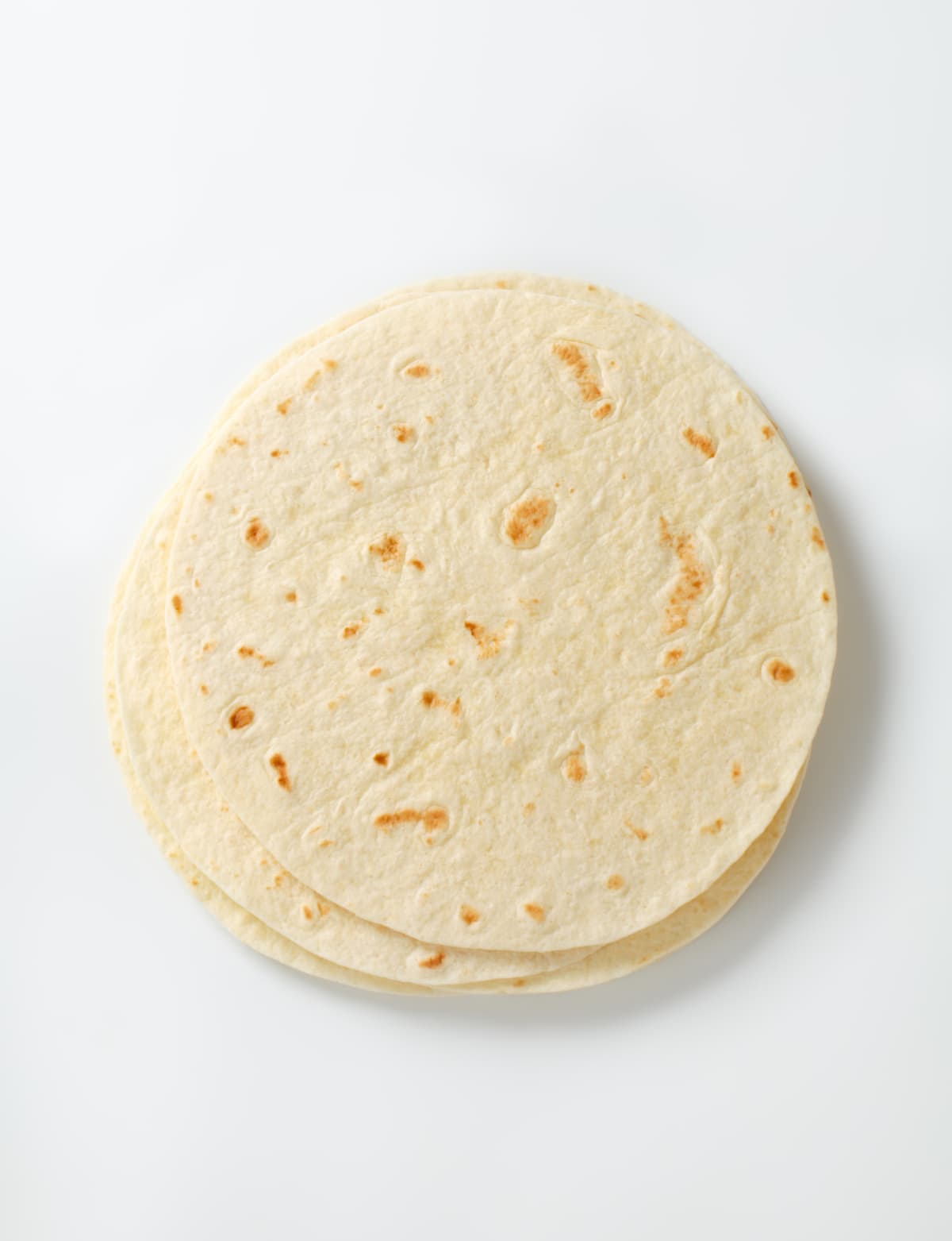 Stack of flour tortillas on a white background