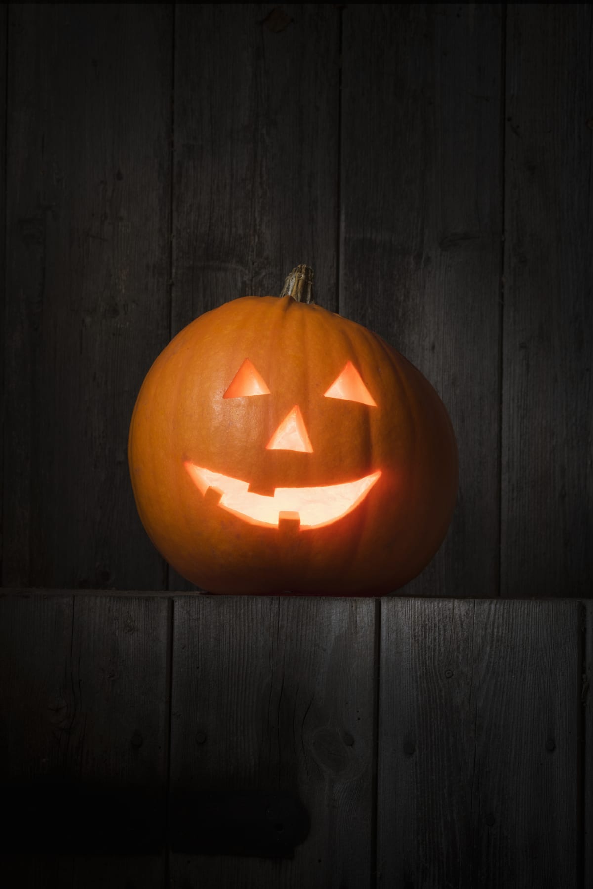 Pumpkin with carved smiling face emitting light