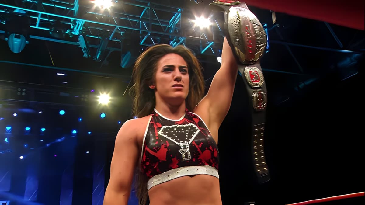 Tessa Blanchard holding a championship belt in the air