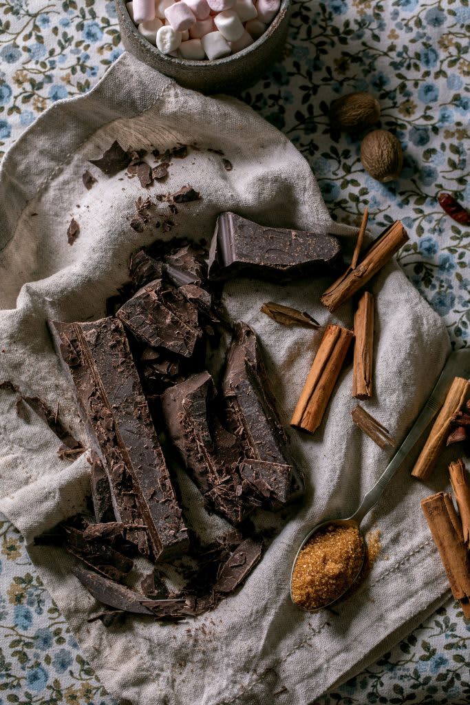 Ingredients for make hot chocolate winter drink. Chopped dark chocolate, species, cane sugar, marshmallows on rustic linen tablecloth in country kitchen. Flat lay. (Photo by: Natasha Breen/REDA&CO/Universal Images Group via Getty Images)
