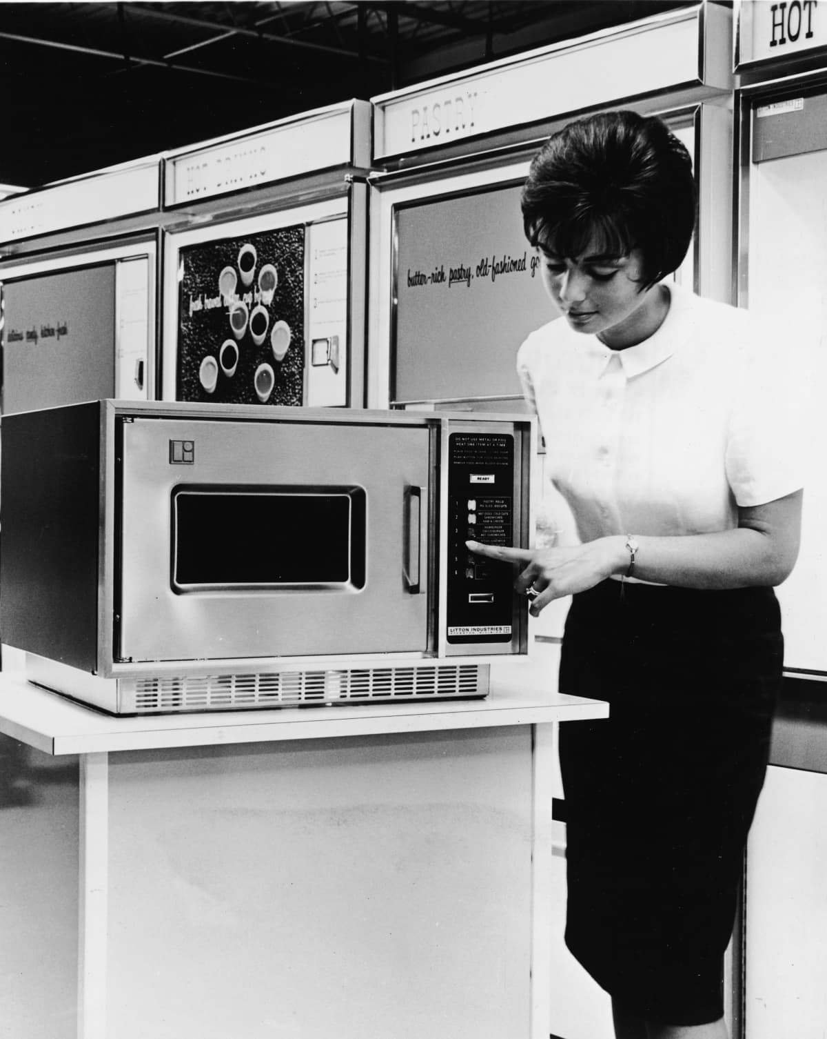 A woman demonstrates a Litton Series 500 microwave oven on a display stand, circa 1966. (Photo by Pictorial Parade/Archive Photos/Getty Images)