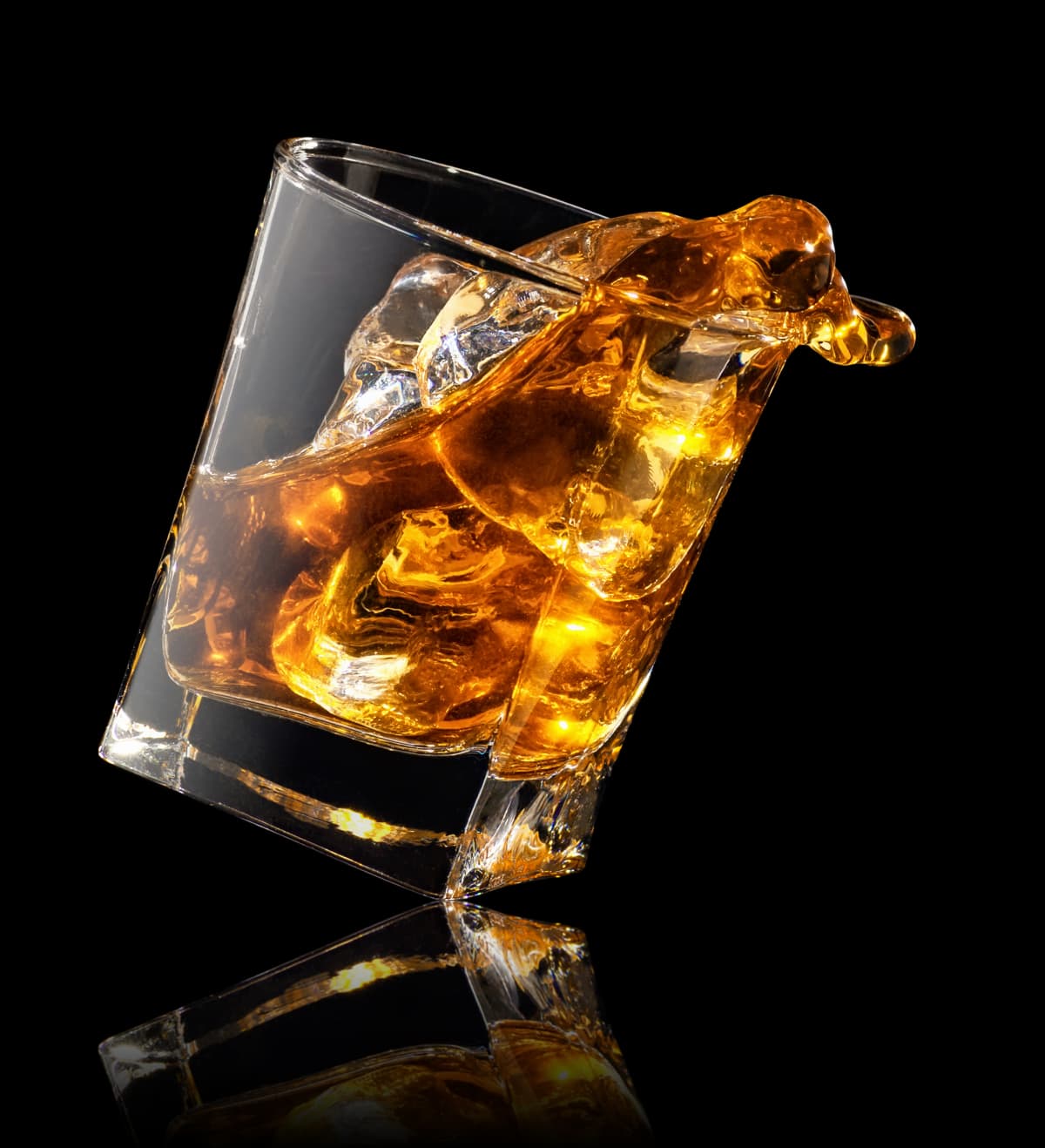 Glass of whiskey with ice isolated on a white background