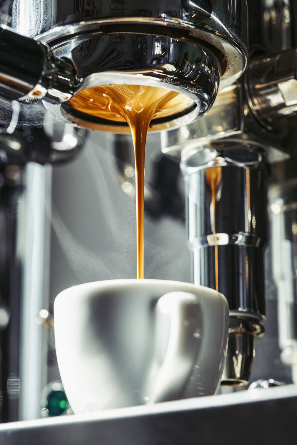 Espresso pouring from machine into cup