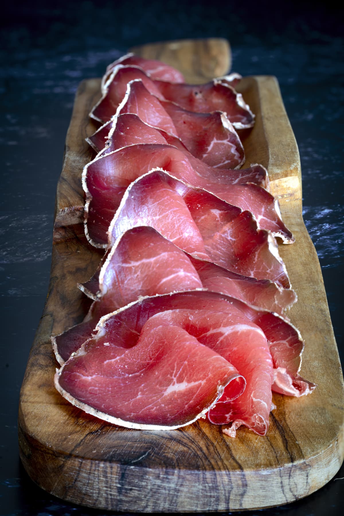 slices of cured meat on a wood cutting board