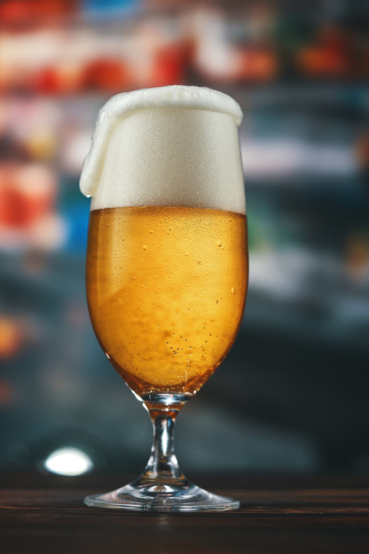 Glass of pale beer with foamy head