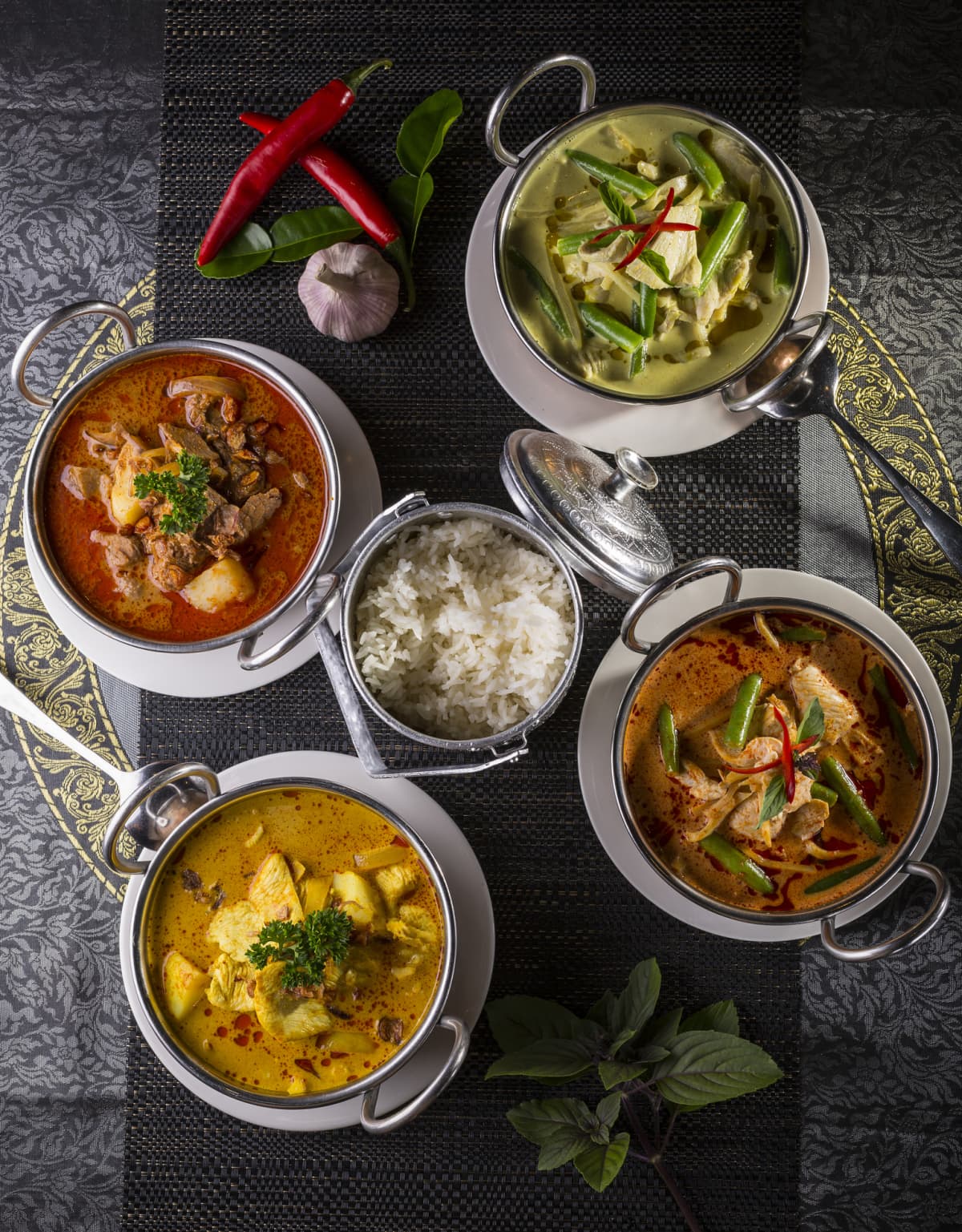 Variety of thai curries in metal bowls