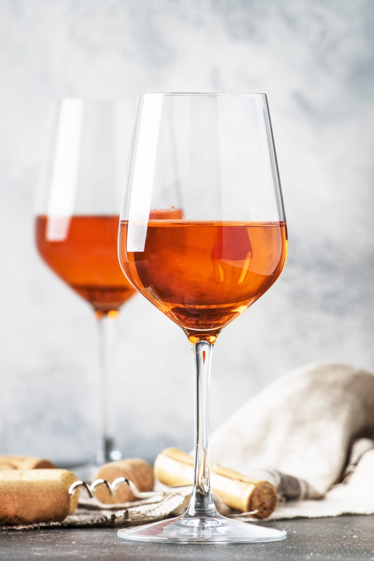 Trendy food and drink, orange wine in glass, gray table, space for text, selective focus
