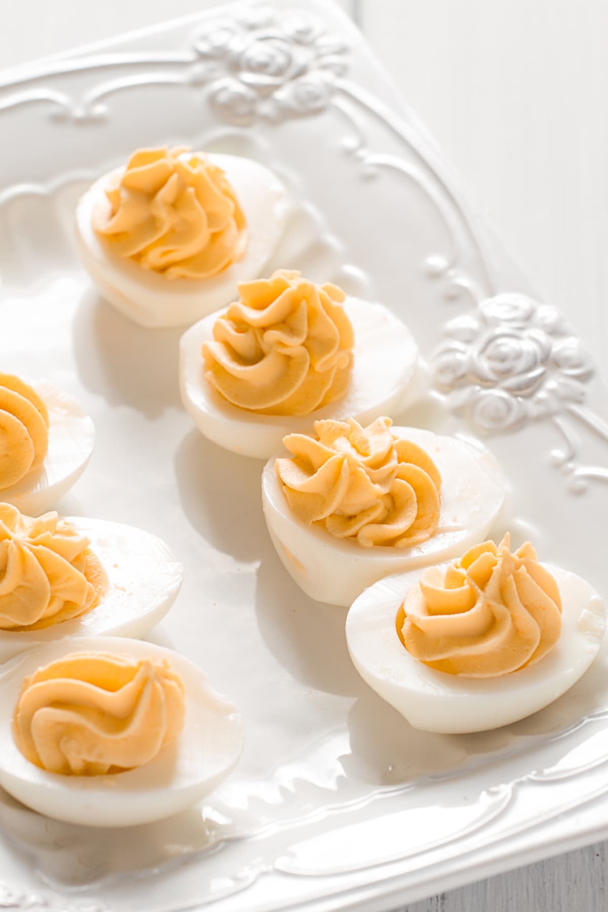 Boiled eggs stuffed with yolk with mayonnaise, on a white plate, selective focus, blurry, close-up, no people,