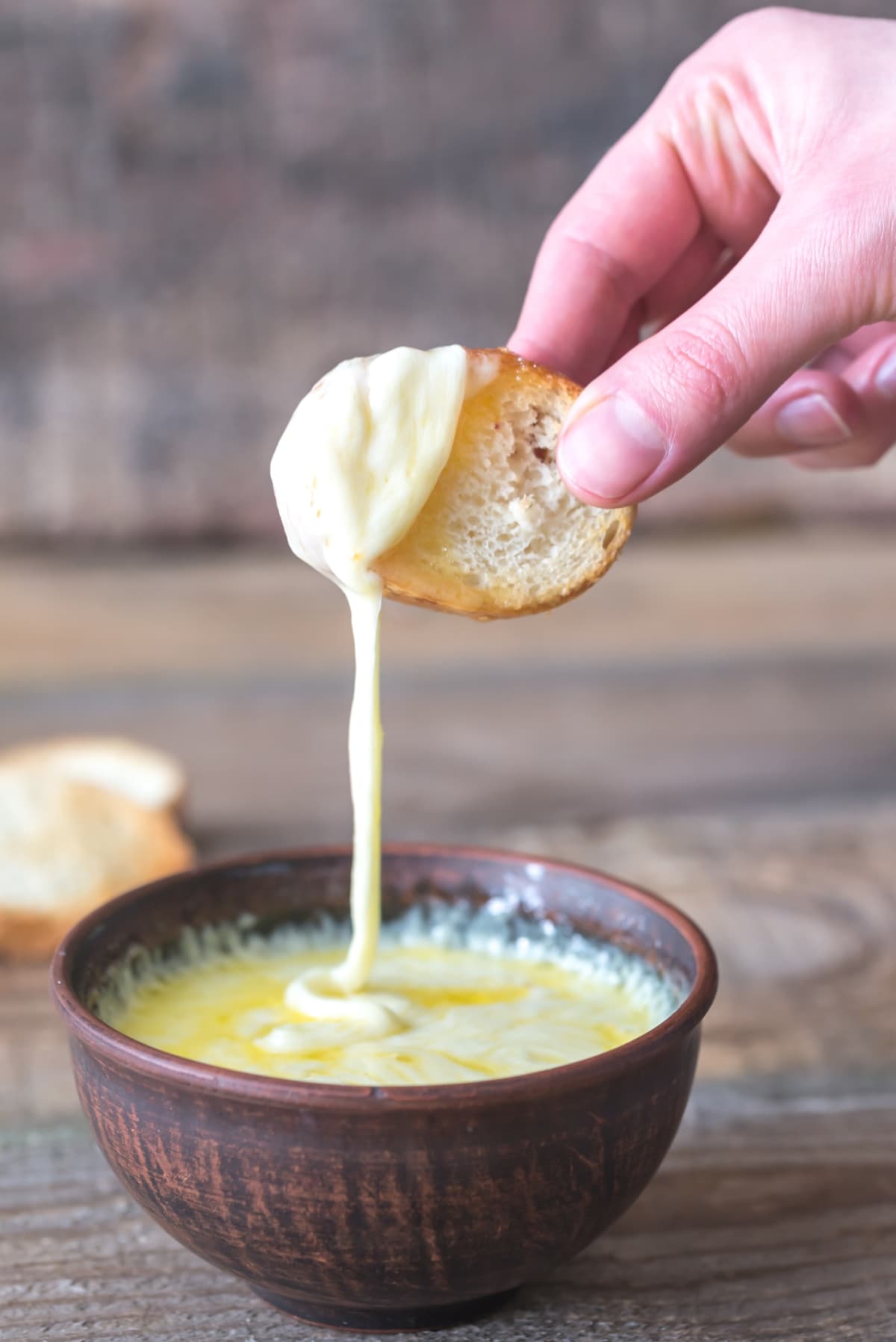Dipping a small toast into queso fundido