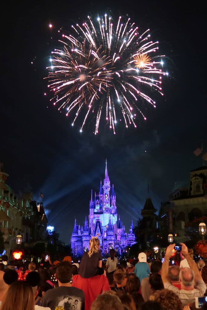 a solitary firework going off above Cinderella's Castle at the Magic Kingdom in Walt Disney World