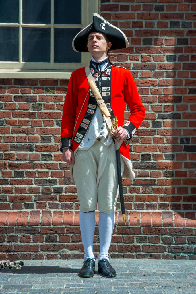 Boston Harborfest Redcoats Soldiers dressed in British Army Uniform reinact a key ceremony parade in front of The Old State House Boston Massachusetts.