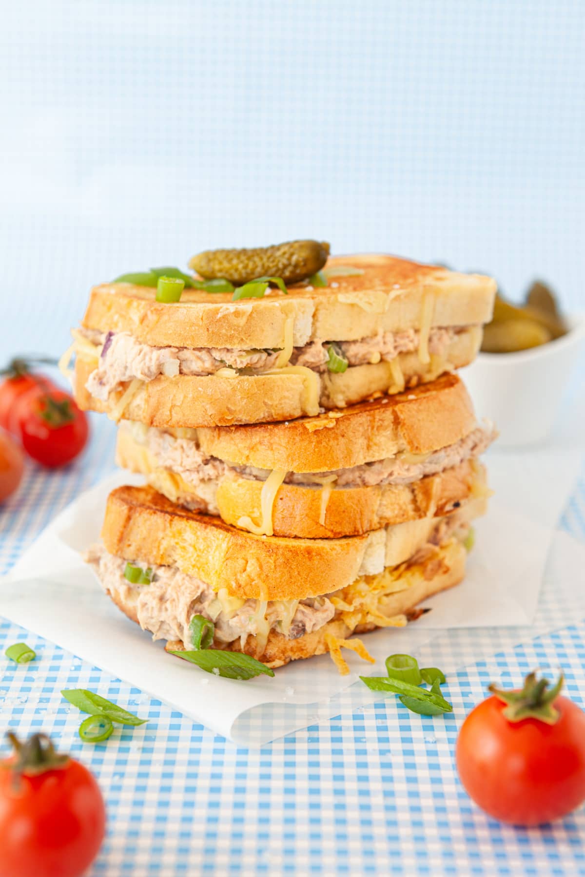 Three tuna melt sandwiches stacked on top of each other 