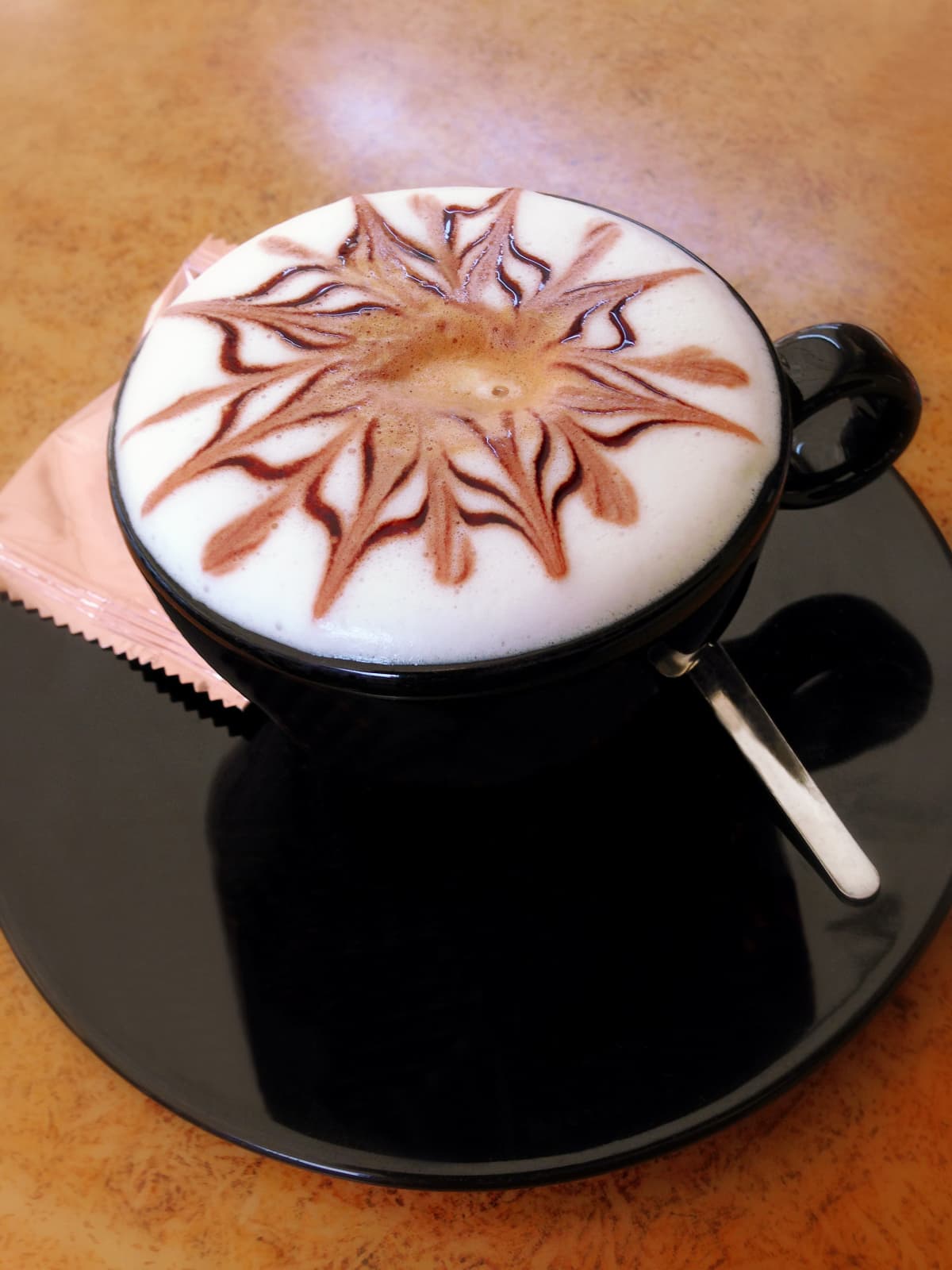 A decorated milk froth in a cup of cappuccino