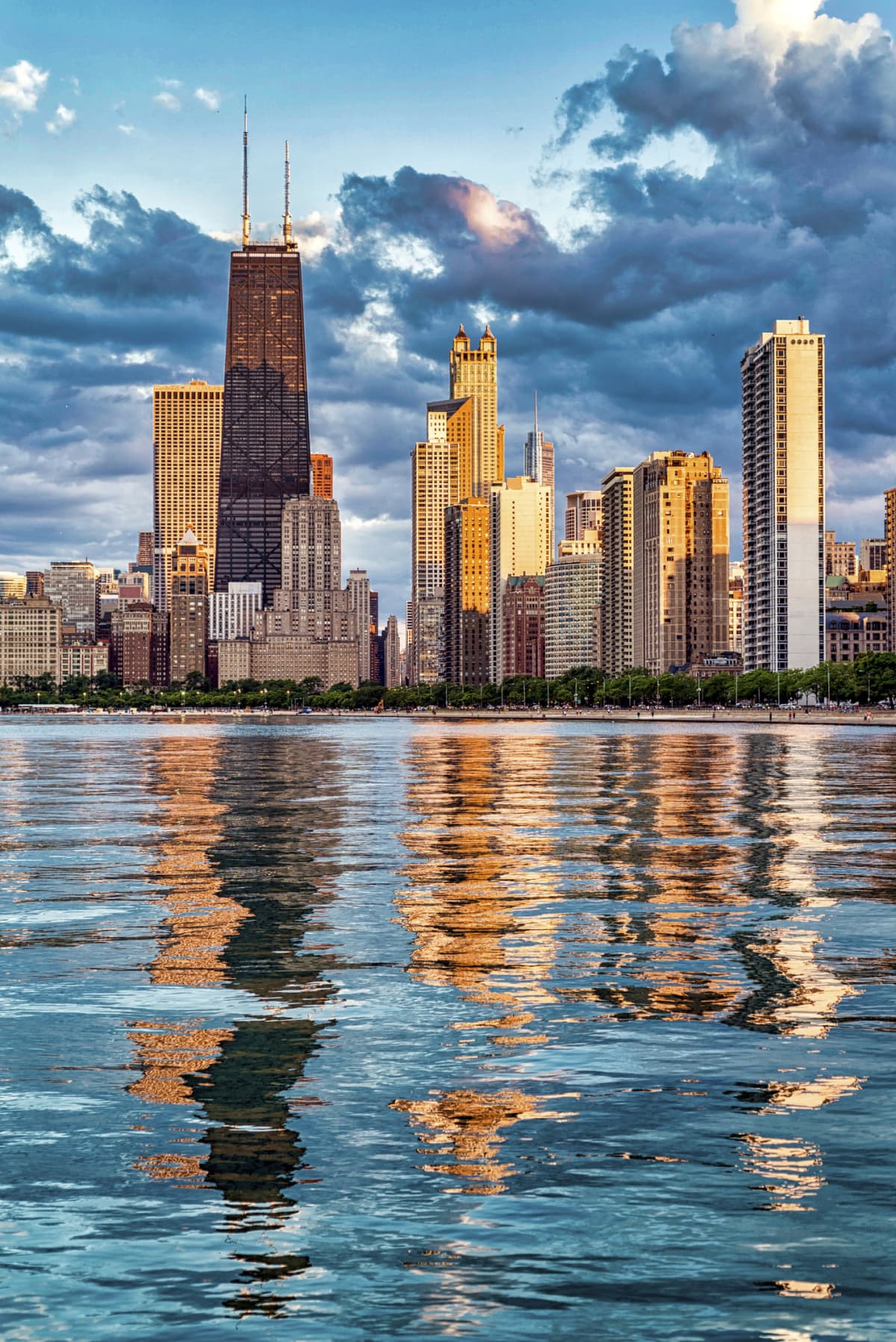 Chicago's skyline bathed in pink sunlight and reflected on the water at sunset