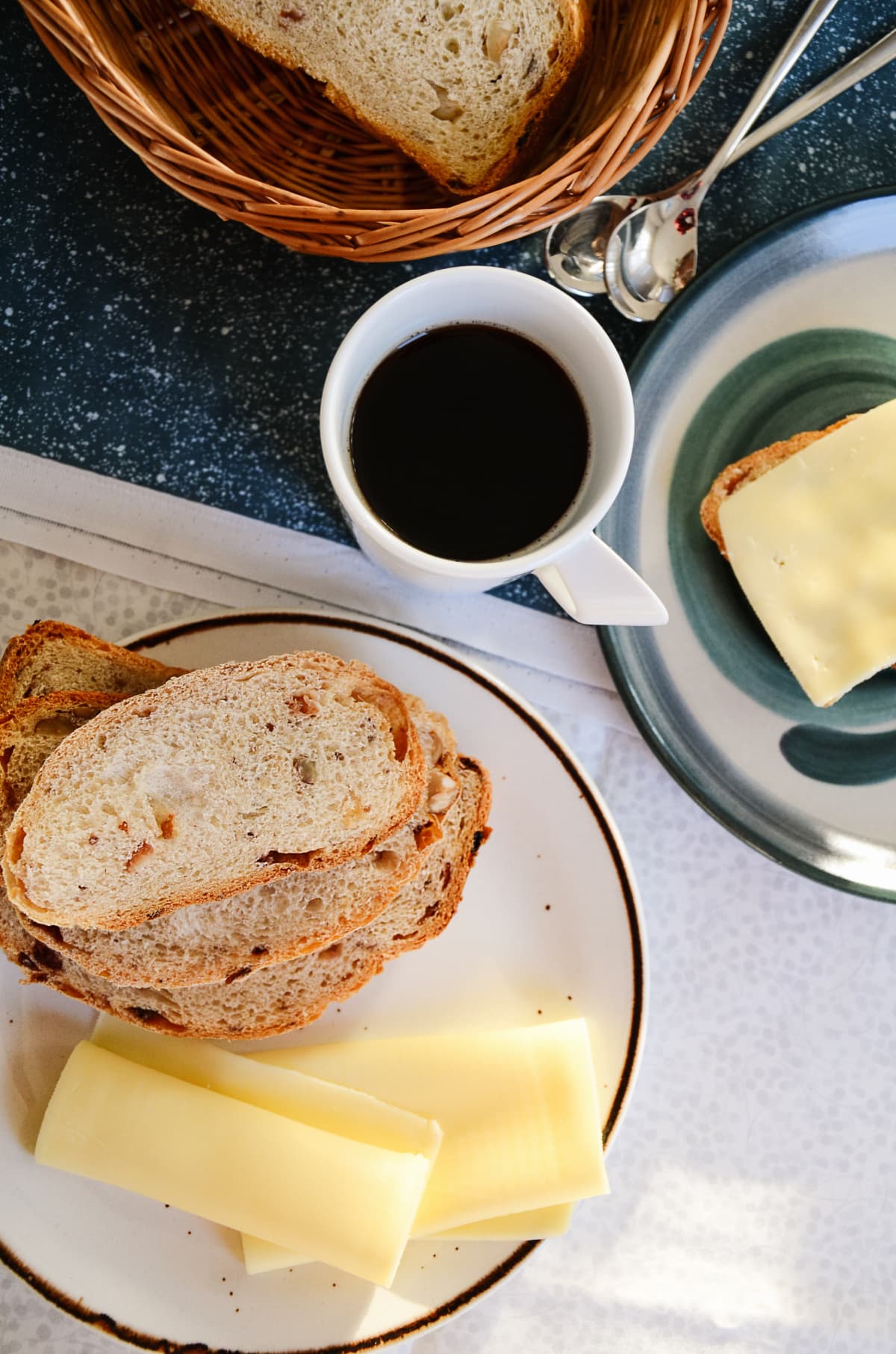 Breakfast with a cup of black coffee, homemade crusty bread and thin cheese slices